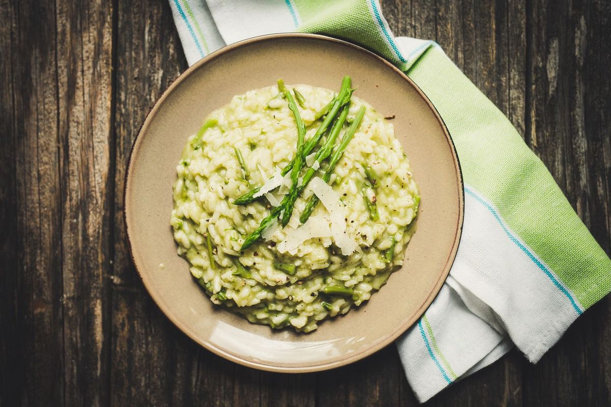 Spargelrisotto serviert und mit Parmesan und grünem Spargel garniert