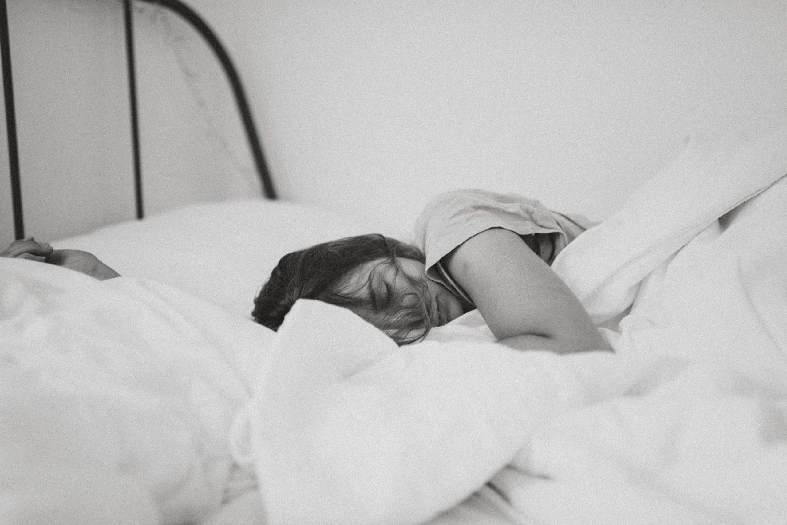 Schwarz-weißes Bild mit Frau, die im Bett liegt und Schläft