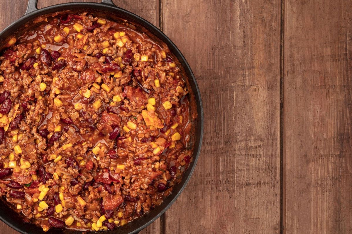 Chili con Carne im Dutch Oven auf Holztisch