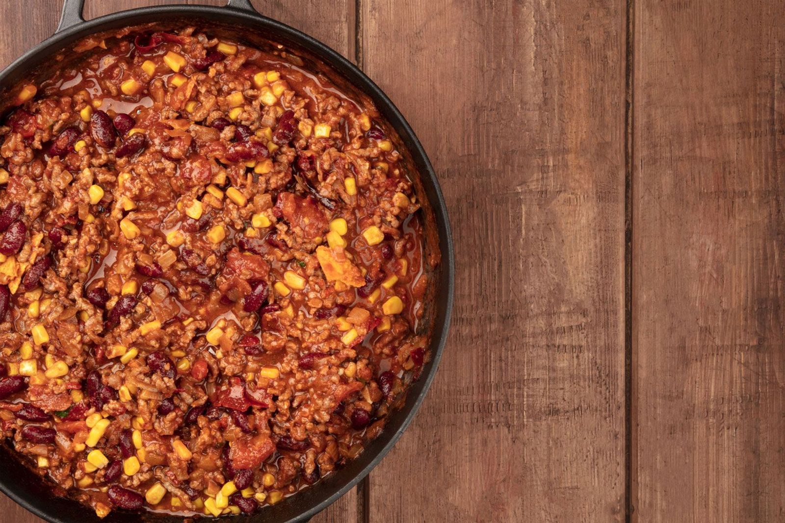 Chili con Carne im Dutch Oven auf Holztisch