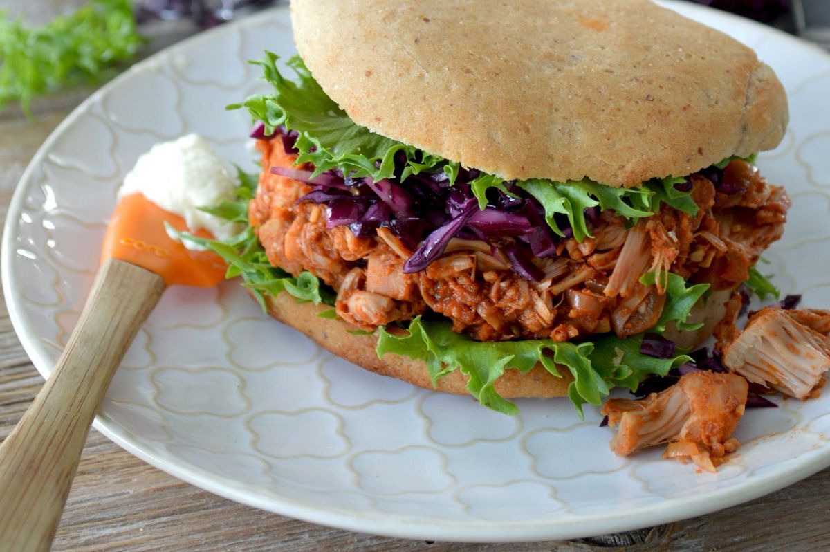 Pulled Jackfruit Burger auf weißem Teller mit Muster und Salat