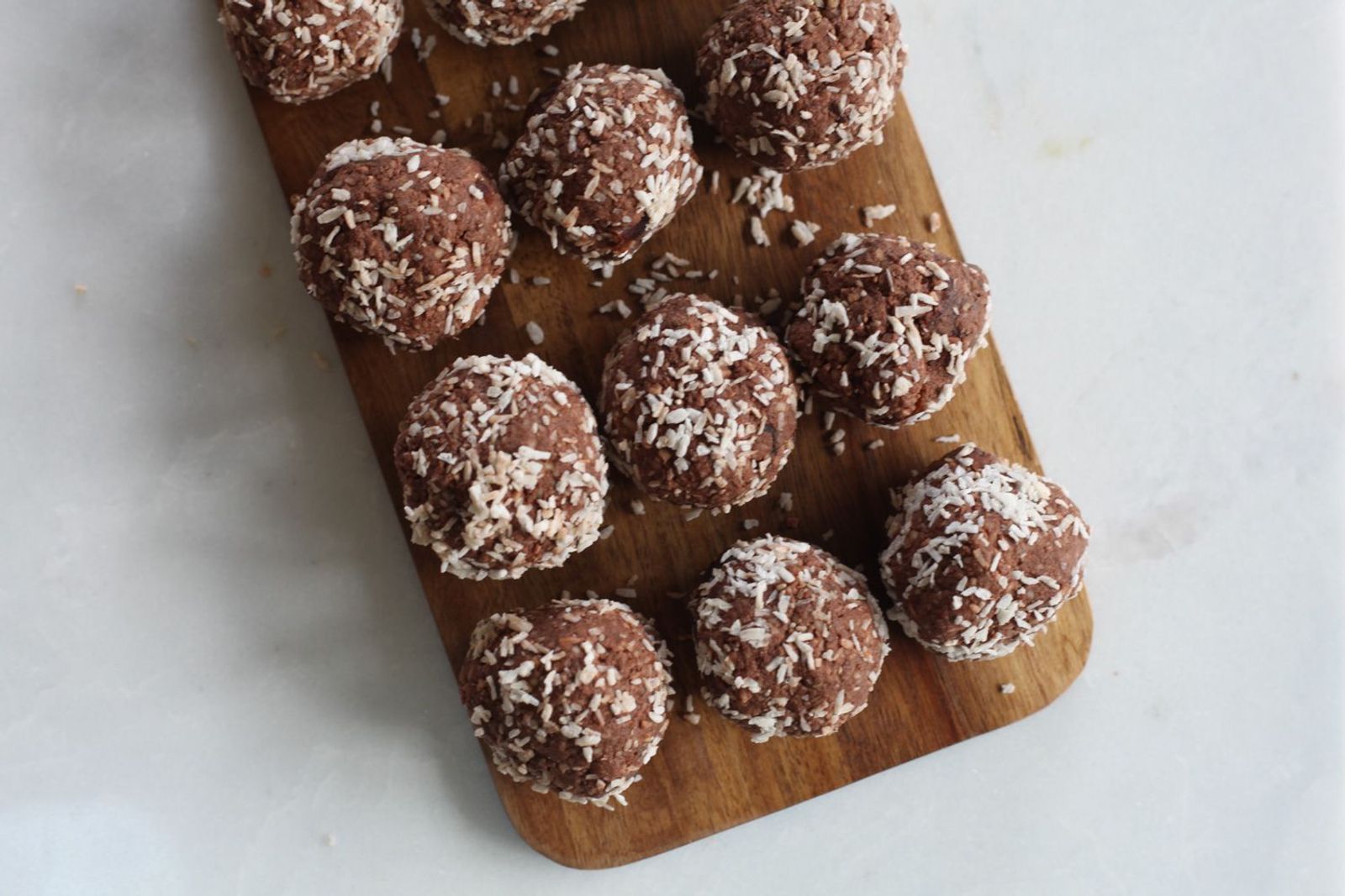 Energy Balls mit Kakao und Kokos auf Brettchen