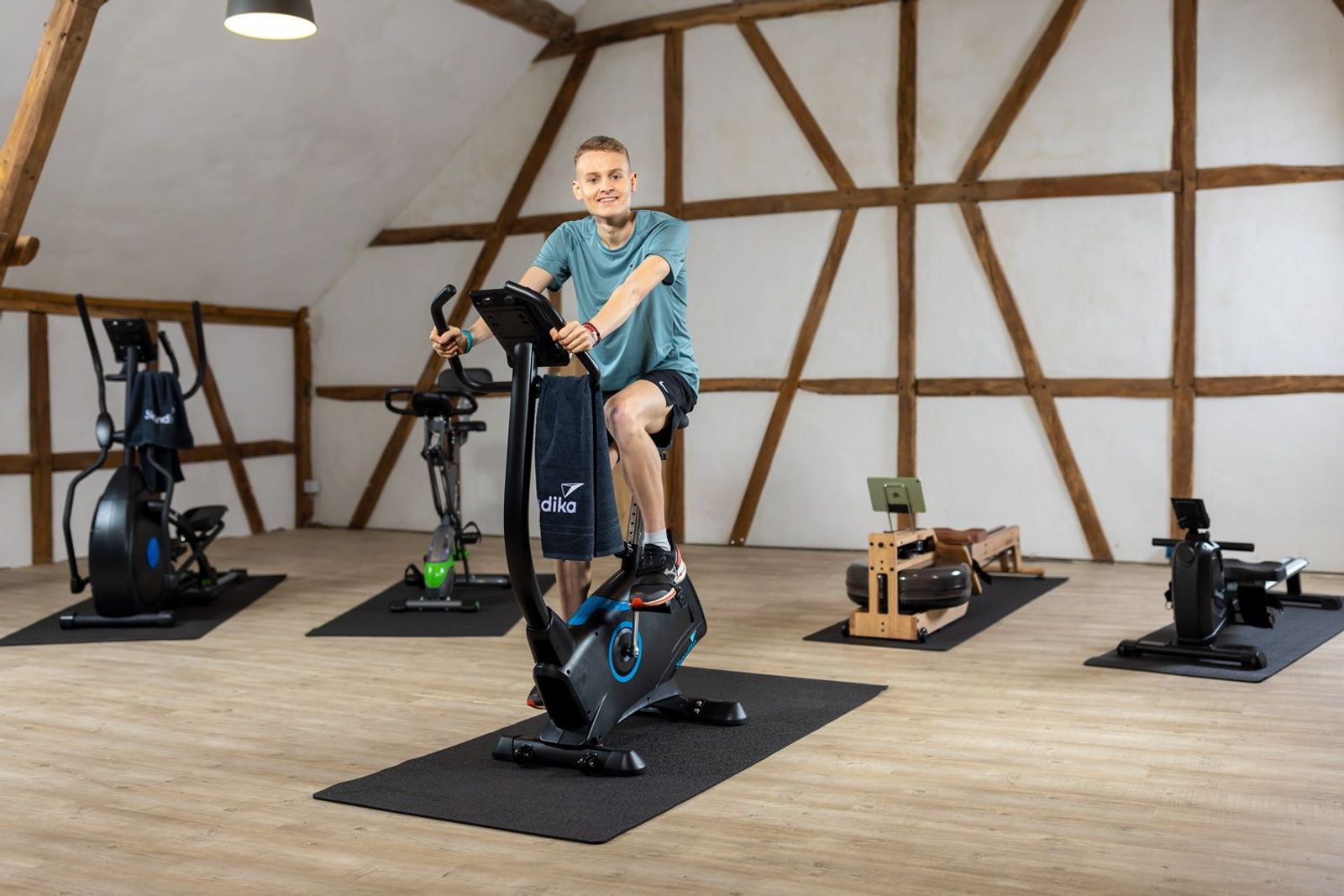 Luke Kelly auf Ergometer mit anderen Fitnessgeräten im Hintergrund