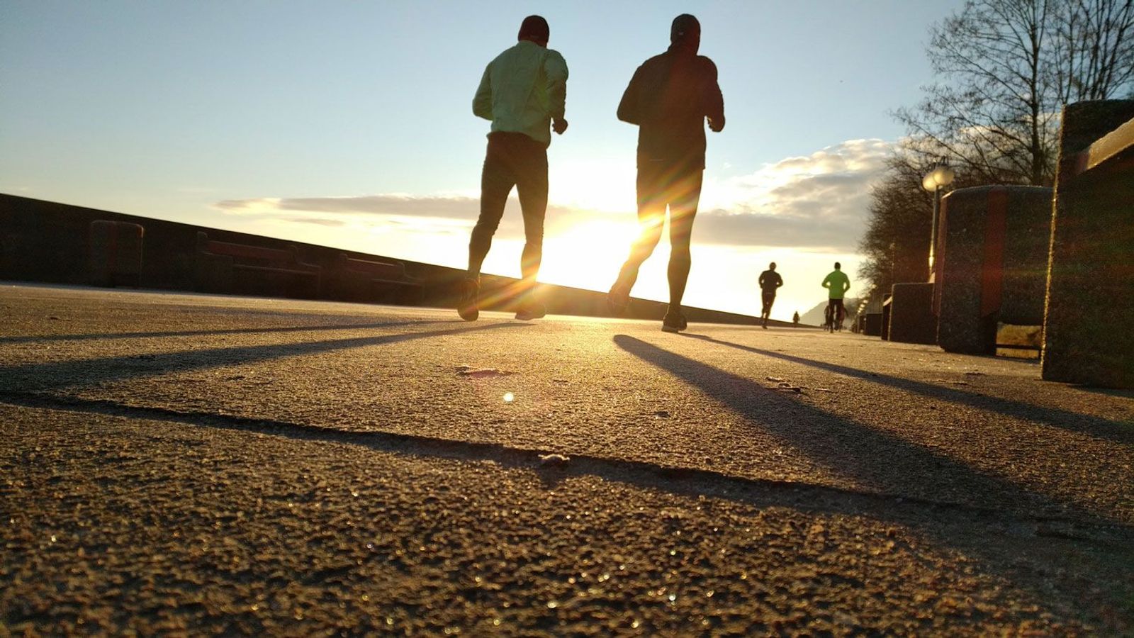 Zwei Jogger beim Sport am Morgen beim Sonnenaufgang 