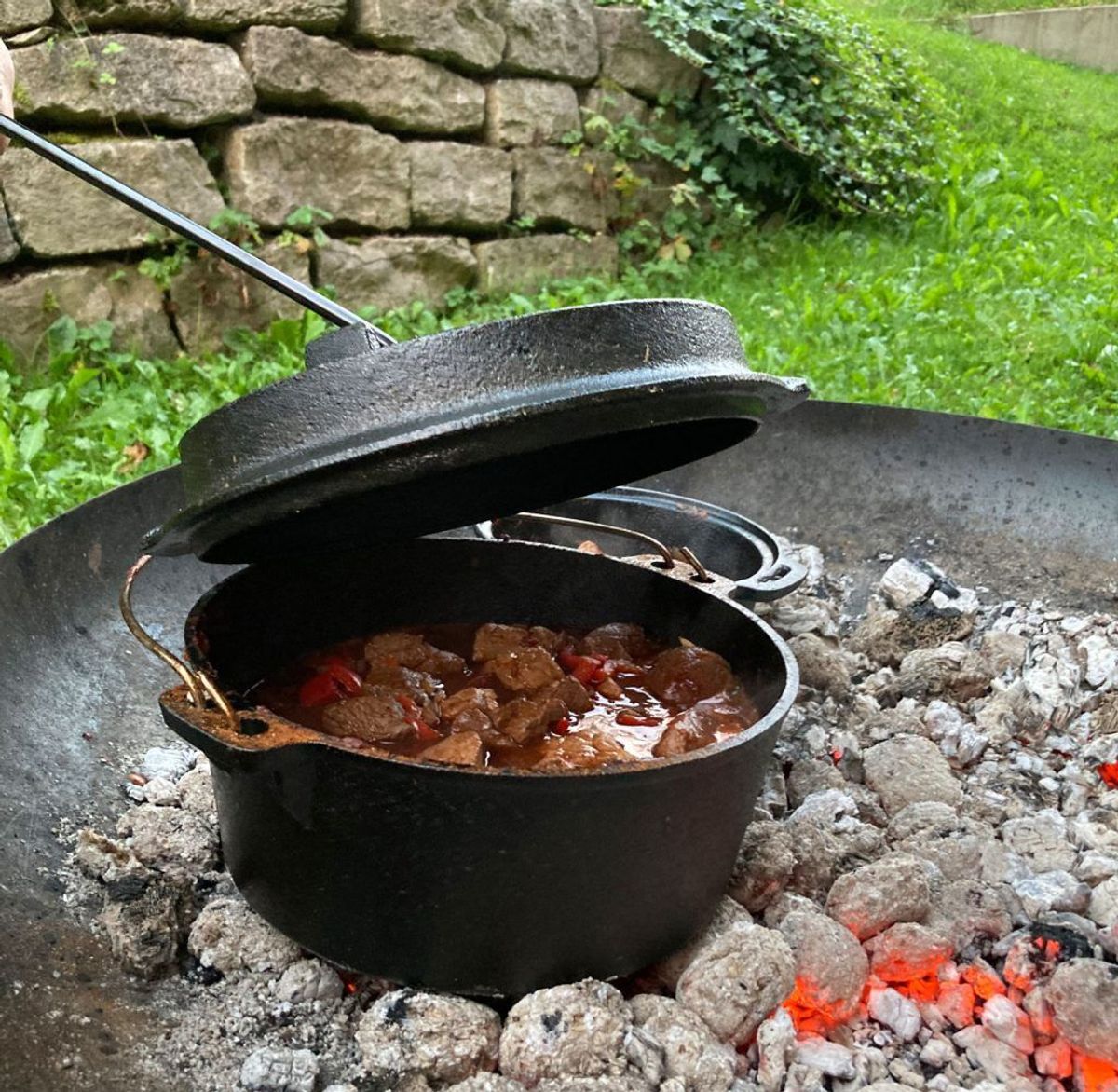 Gulasch im Dutch Oven über der Glut in der Feuerschale