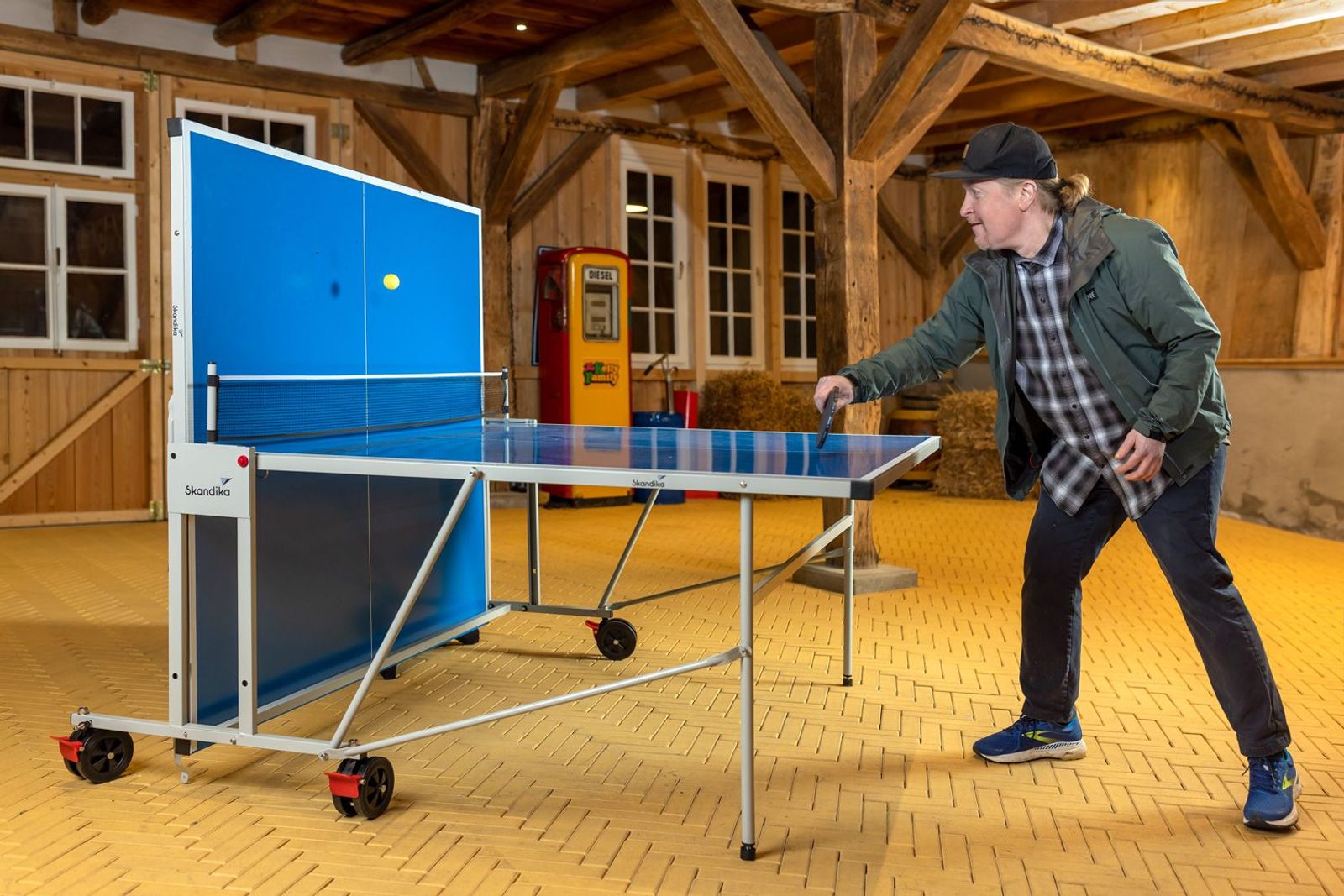 Joey Kelly mit auf einer Seite hochgeklappter Tischtennisplatte, um im Single-Modus zu spielen