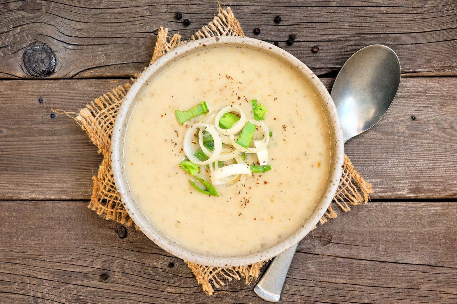 Kartoffelsuppe mit Lauch auf Holztisch