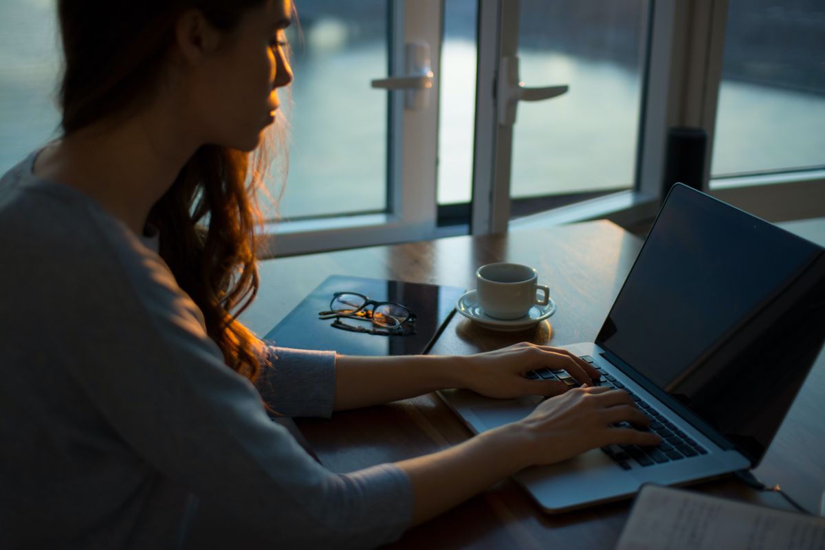 Frau am Schreibtisch tippend am Laptop 