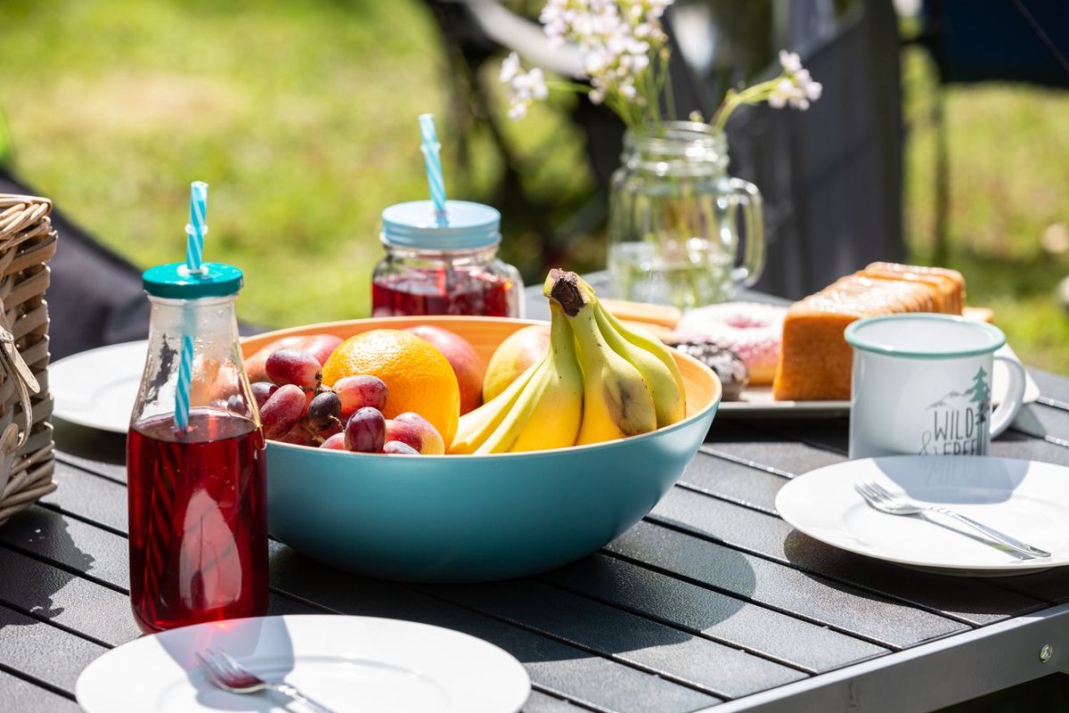 Gedeckter Campingtisch mit Essen und Getränken