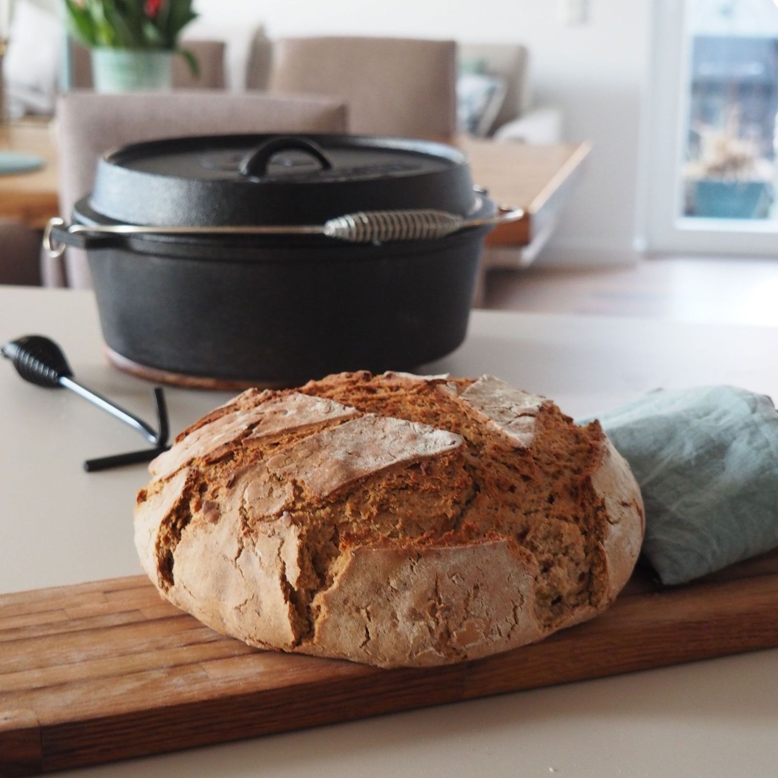 Gebackenes Brot mit Dutch Oven im Hintergrund