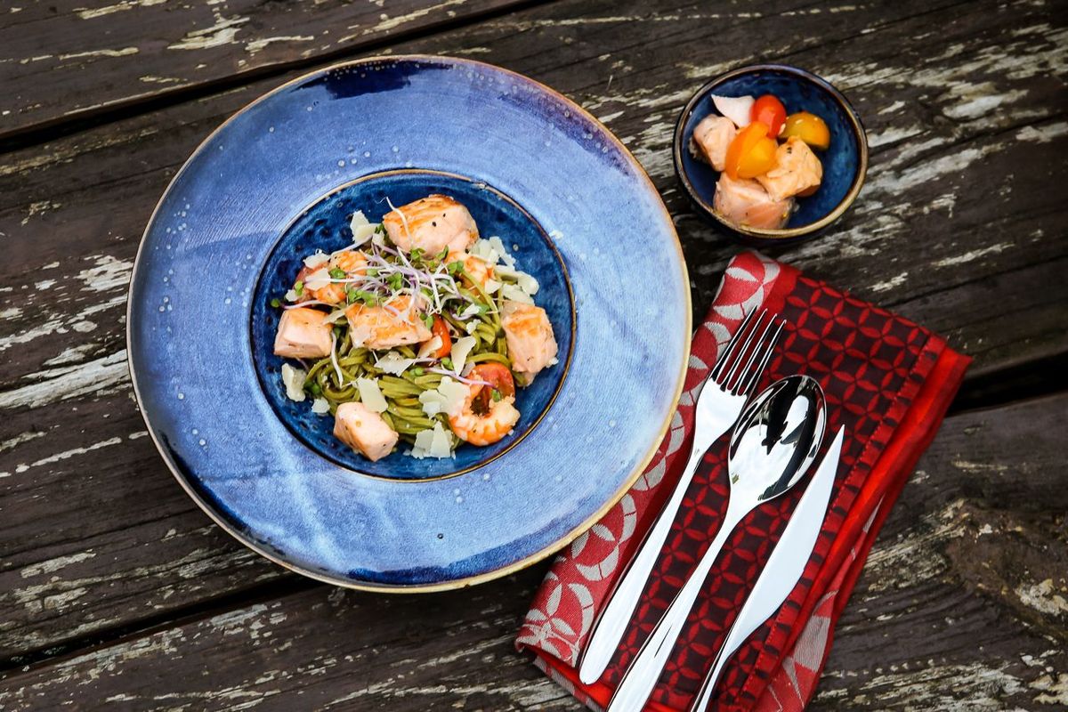 Grüne Pasta aus dem Dutch Oven serviert mit Lachs, Parmesan und Pinienkernen