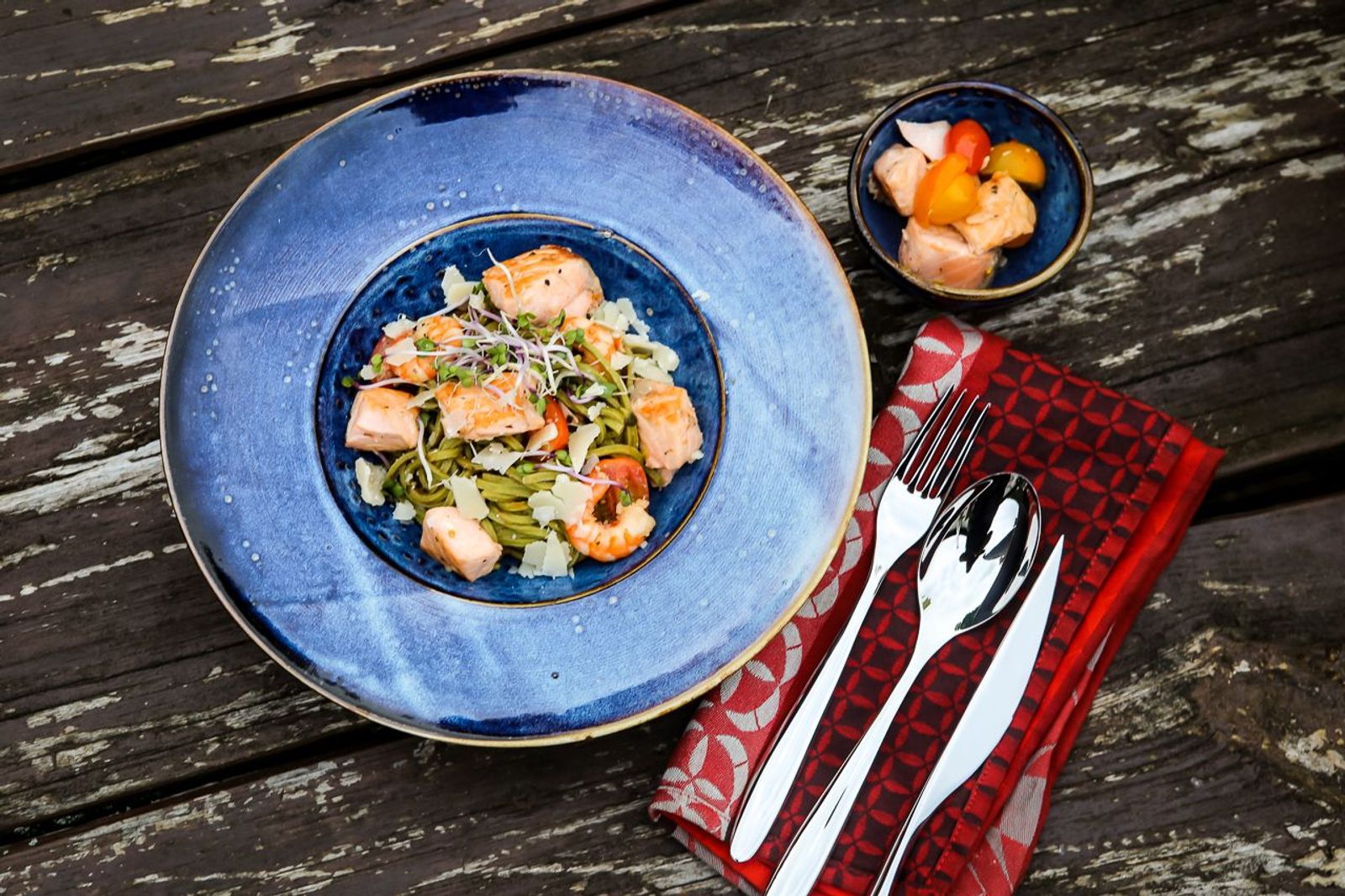 Grüne Pasta aus dem Dutch Oven serviert mit Lachs, Parmesan und Pinienkernen