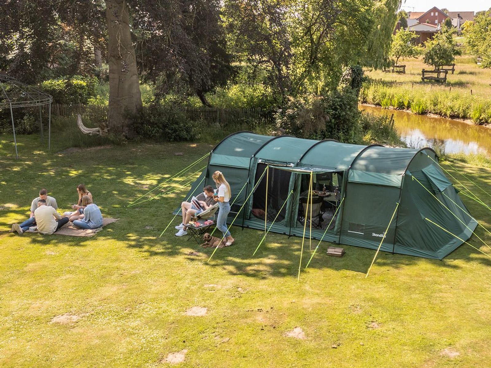 Montana 10 Sleeper Protect in grün auf einer Wiese im Schatten aufgestellt