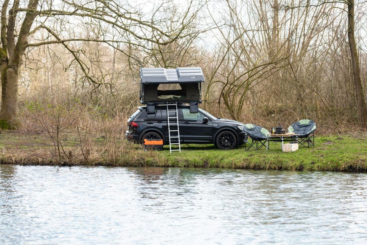 Dachzelt Wildland montiert auf Auto in der Natur neben Moonchair Stühlen