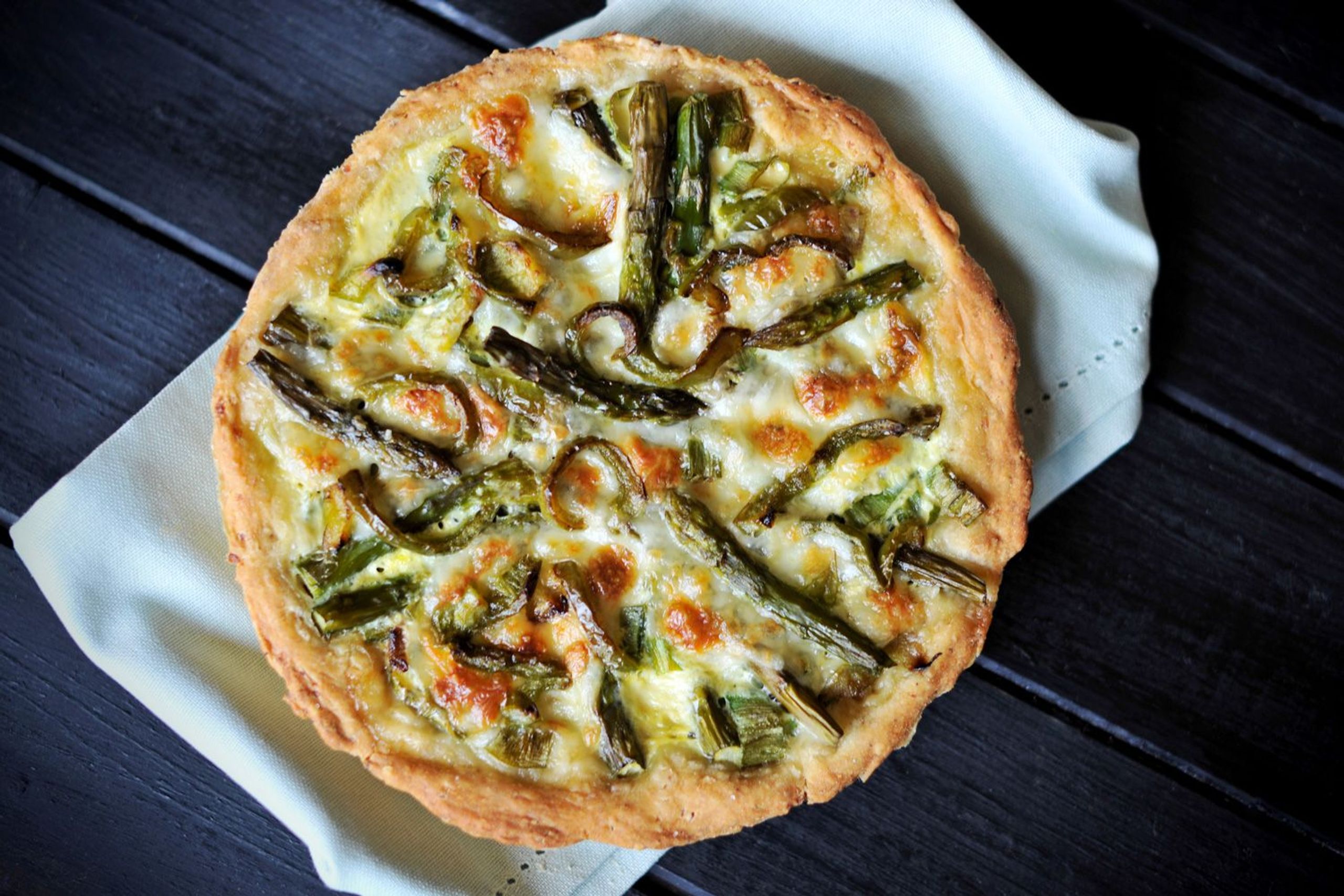 Spargelquiche aus dem Dutch Oven auf einem schwarzen Holztisch