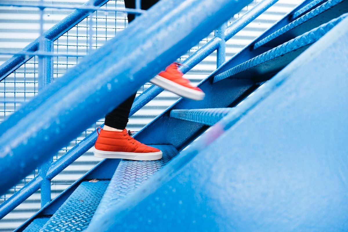 Person mit roten Schuhen auf blauer Treppe