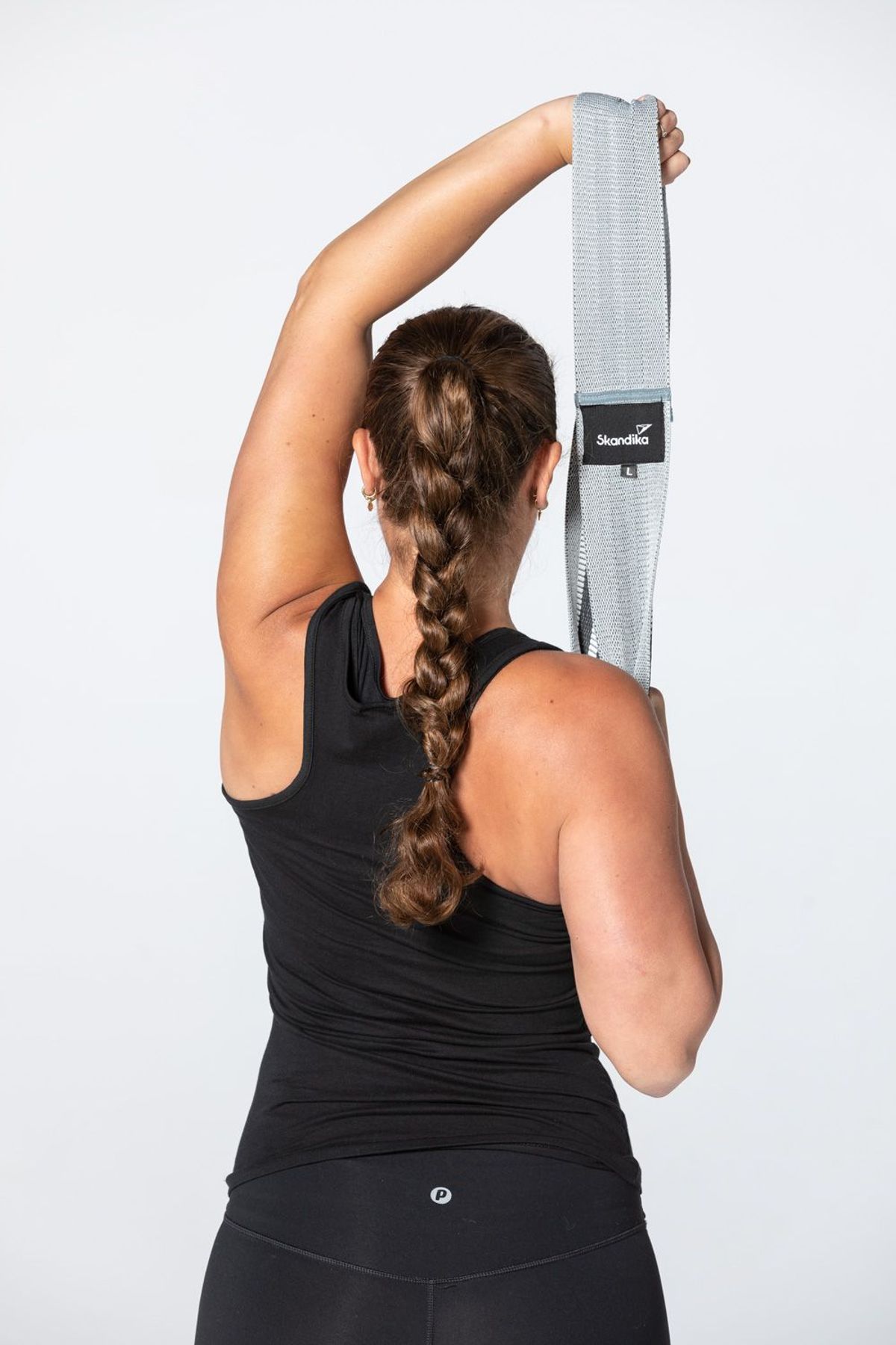 Sportlerin bei Triceps Extension mit Loop Band