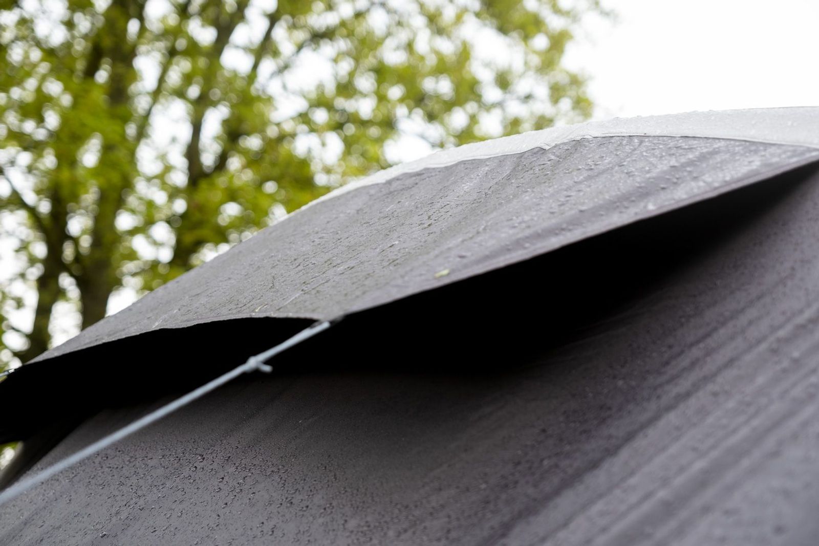 Detailansicht der Belüftungsöffnung beim Zelt mit Bäumen im Hintergrund