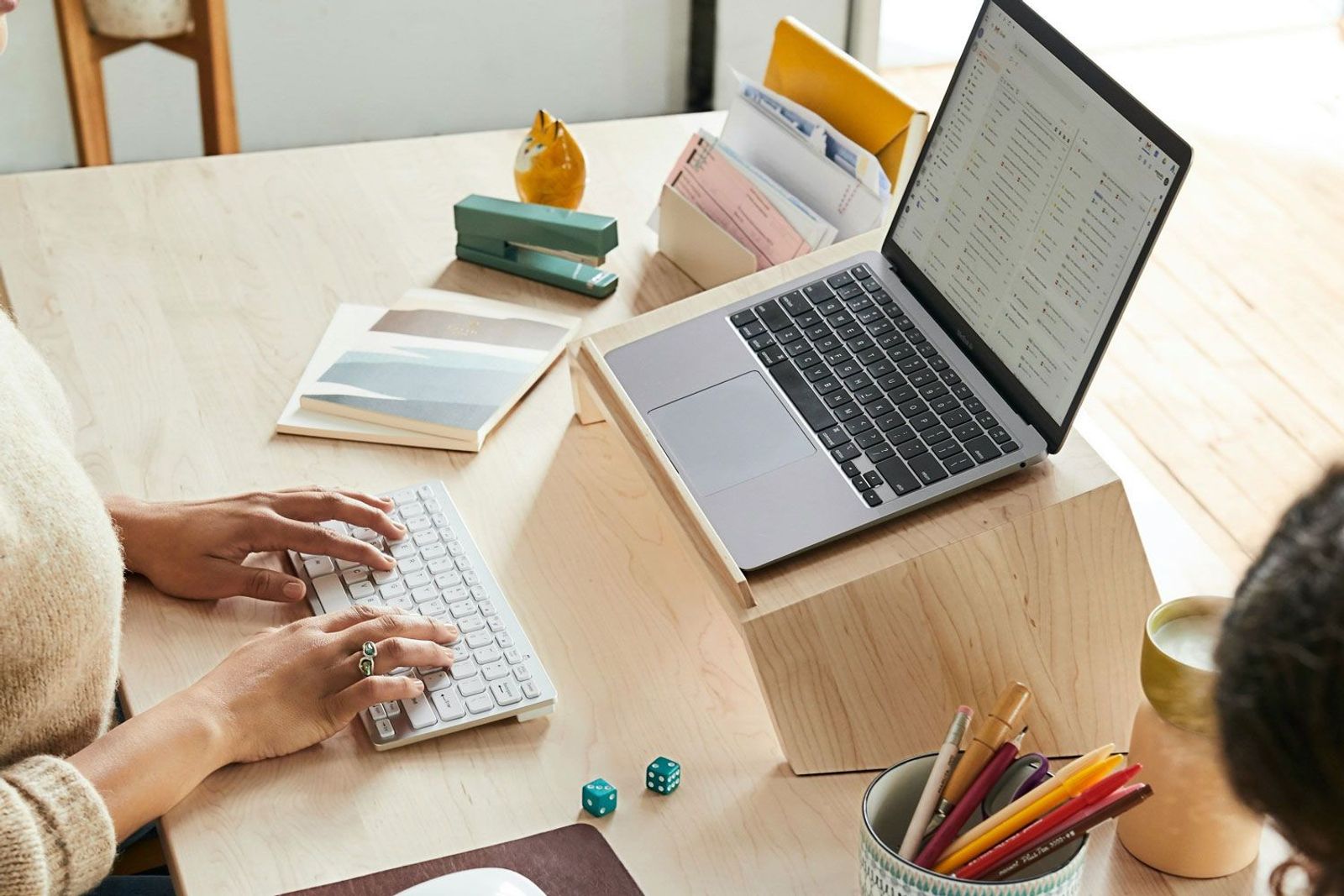 Frau am Schreibtisch mit erhöhter Laptop Position für eine ergonomische Arbeitshaltung