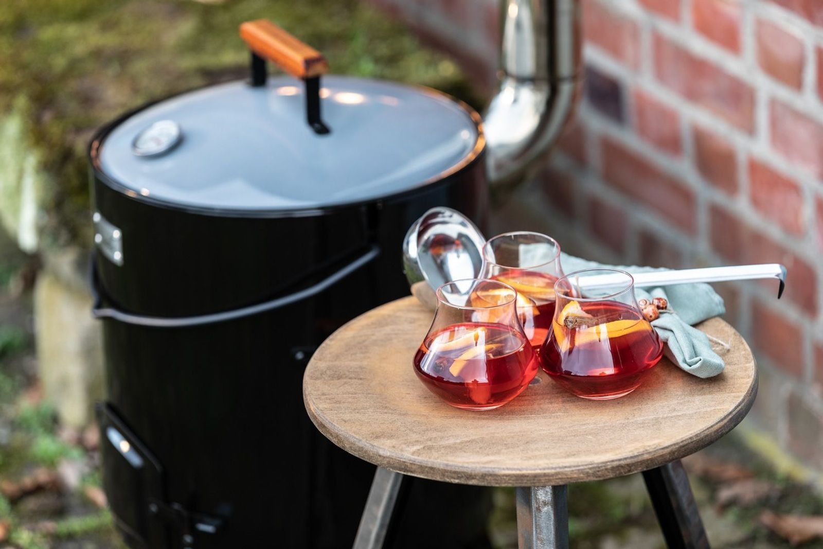 Glüh-Gin in drei Gläsern auf einem Tisch neben einer Gulaschkanone