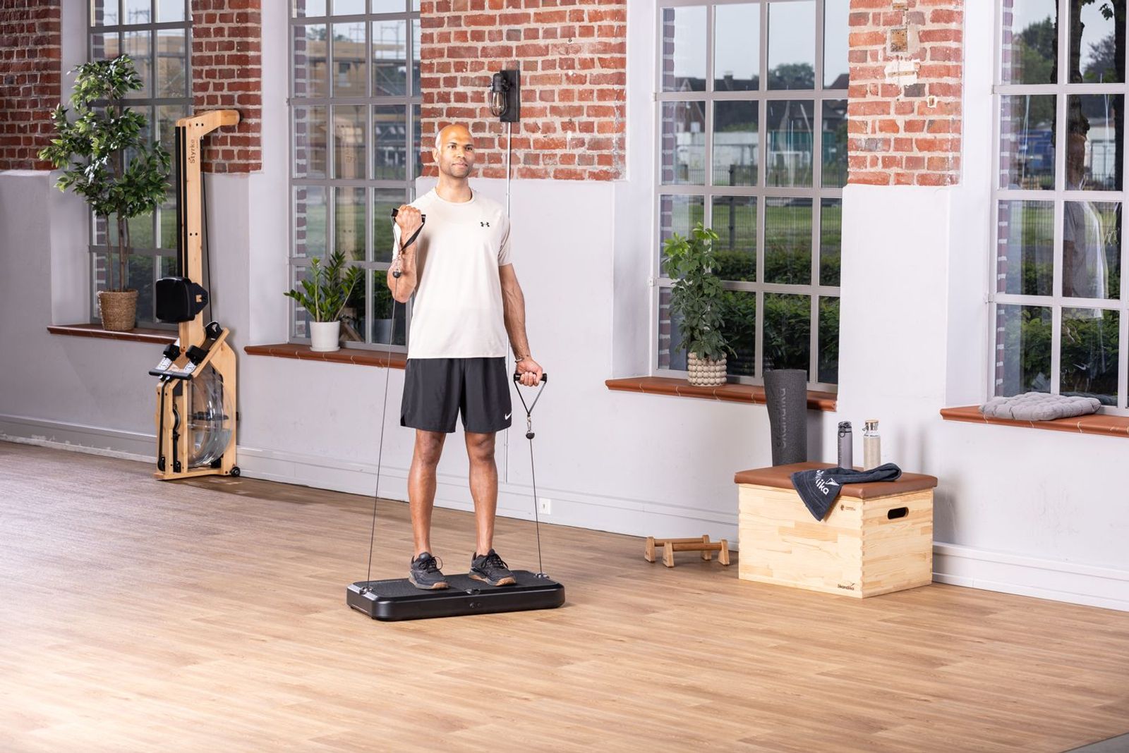 Sportler auf einer Kraftstation beim Workout mit Fitnessequipment im Hintergrund