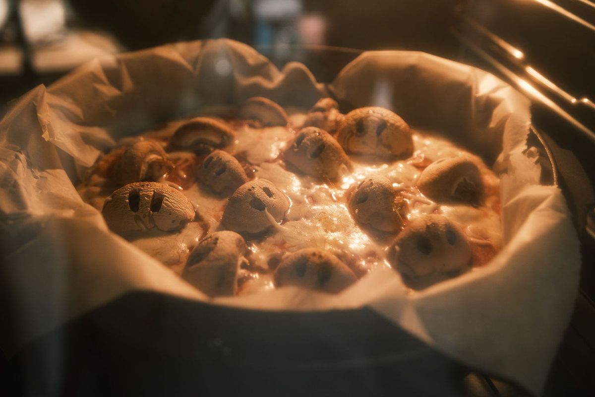 Pizza mit Totenköpfen aus Champignons im Backofen