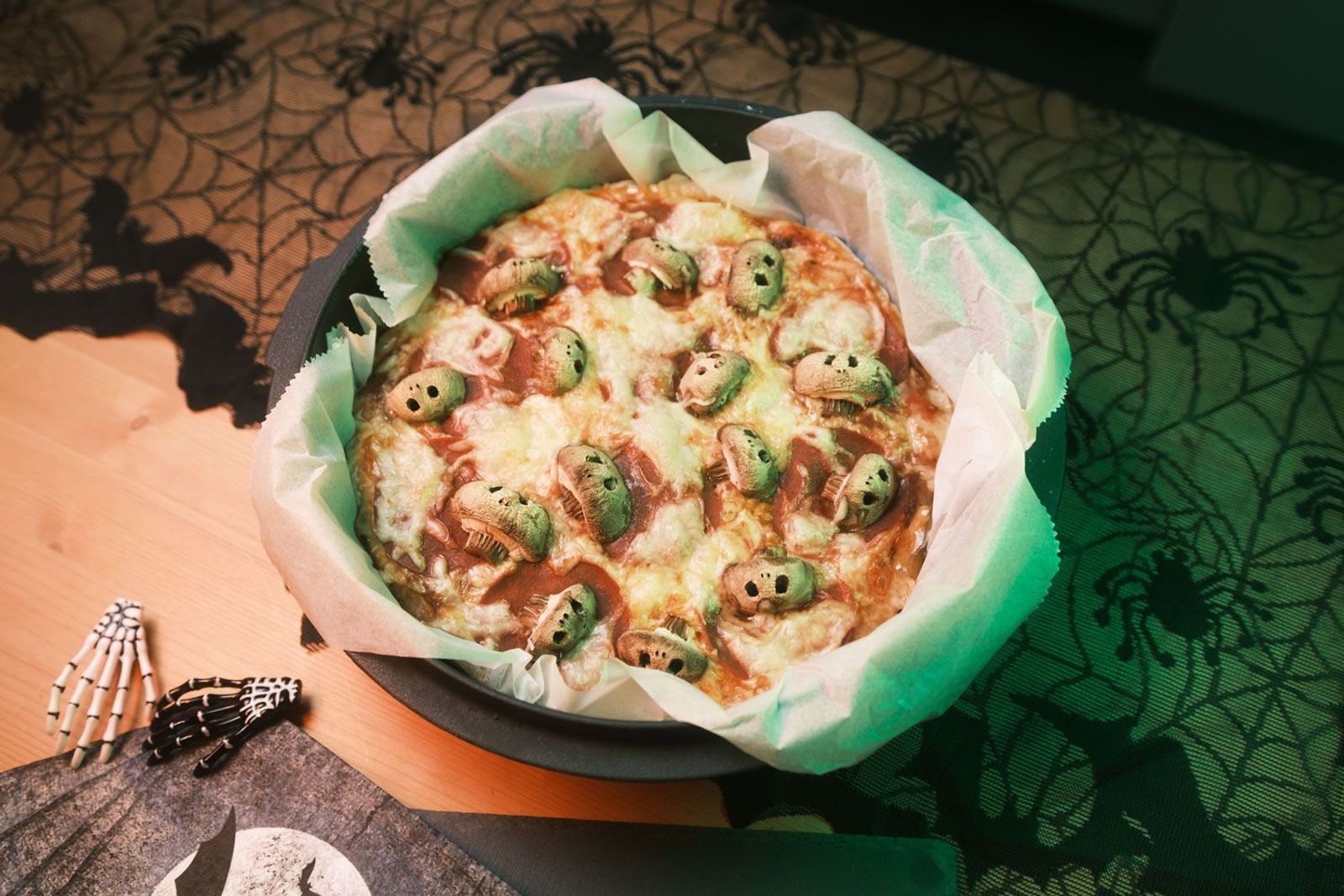 Champignon-Totenkopf Pizza im Dutch Oven mit Halloween Deko im Hintergrund