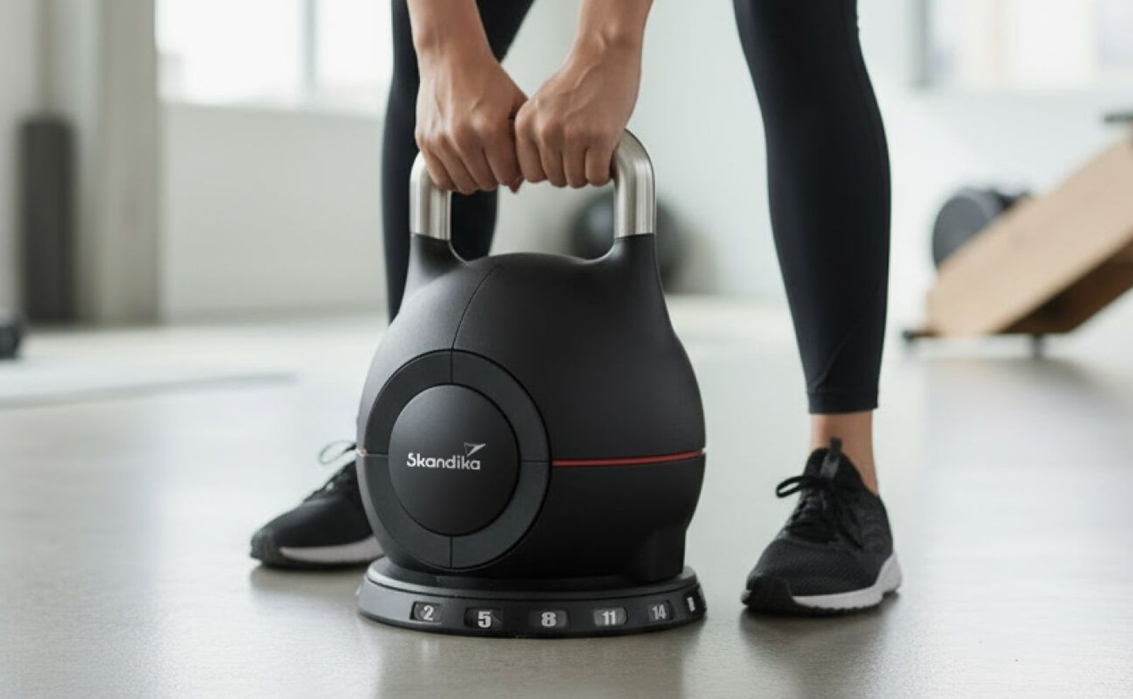 Kettlebell im Fokus und eine Sportlerin, die diese von oben greift